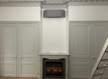Climatisation réversible gris anthracite au-dessus d'une cheminée en marbre, appartement ancien à Charlieu